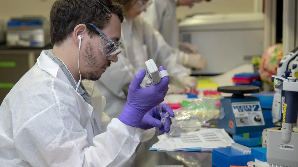 DNA analysts working with sequencing equipment in a laboratory