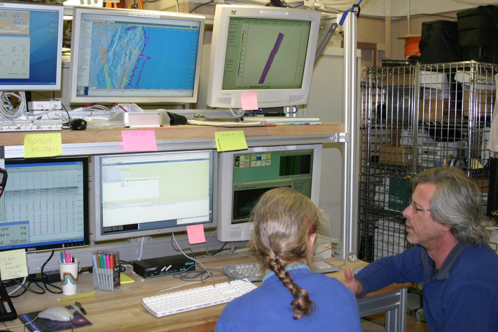 Two USGS scientists discussing incoming research data in a shipboard computer laboratory