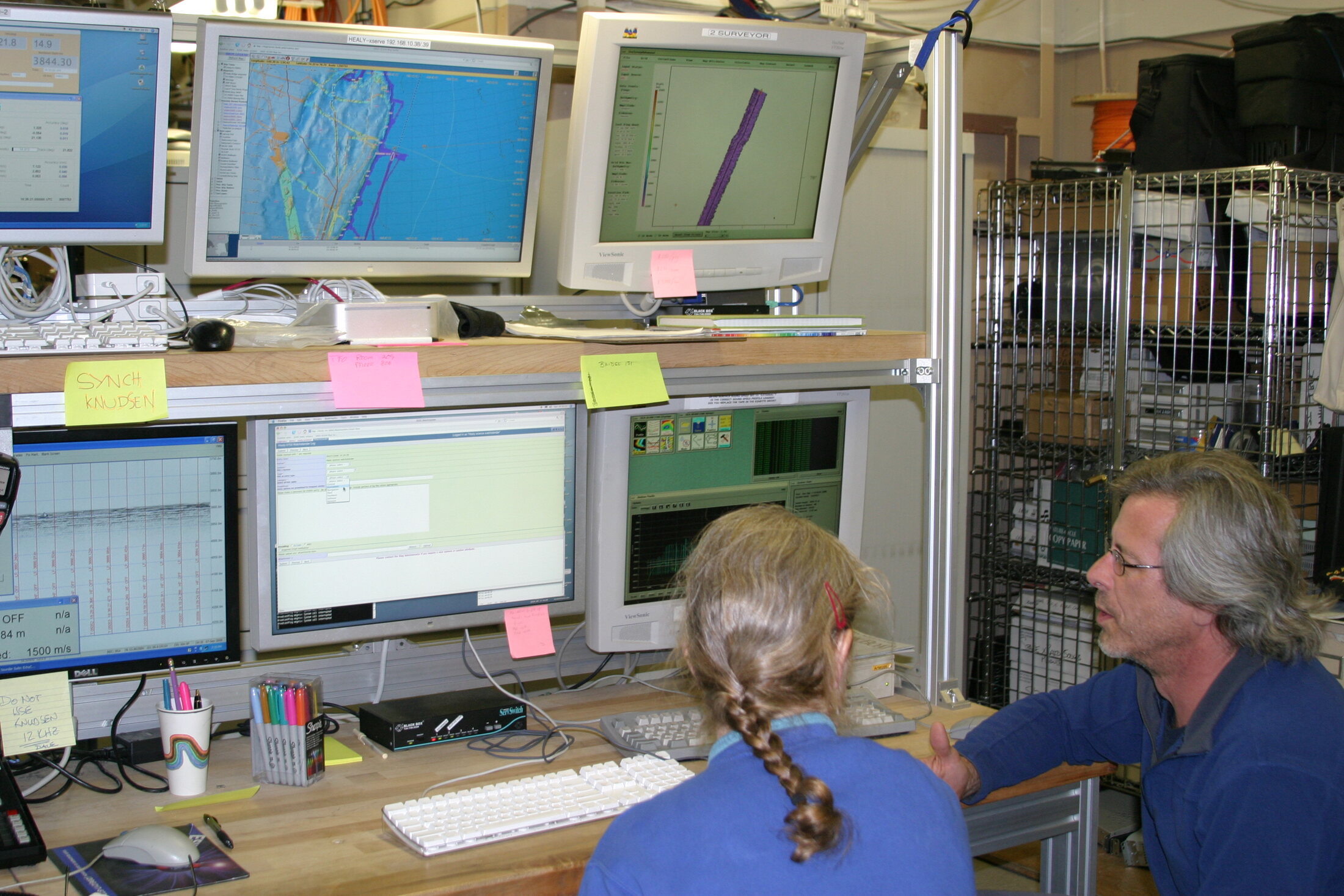 Two USGS scientists discussing incoming research data in a shipboard computer laboratory