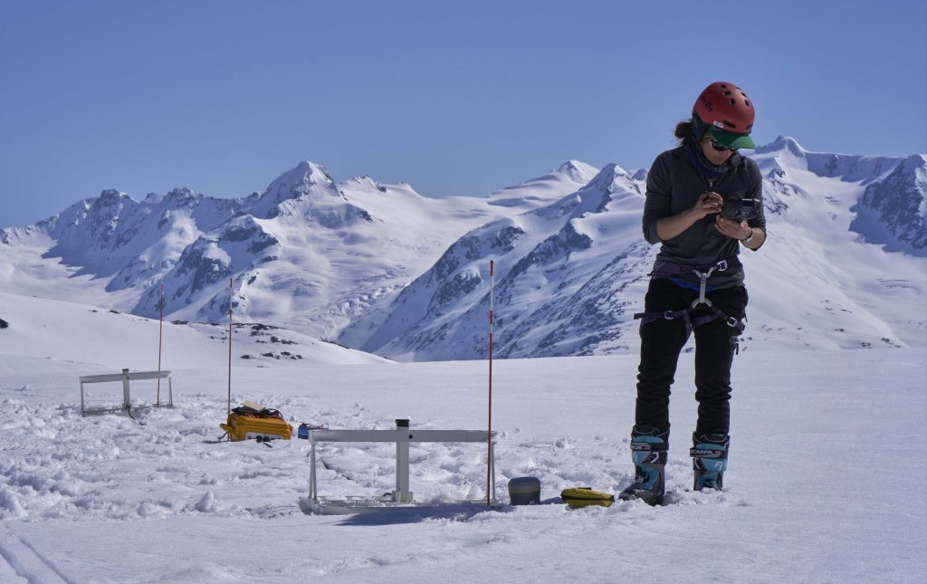 USGS scientist recording glacier research data on a handheld computer