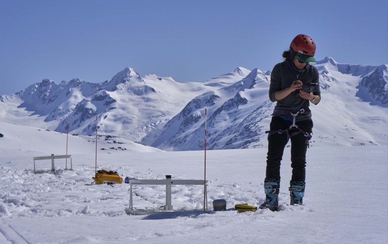 USGS scientist recording glacier research data on a handheld computer