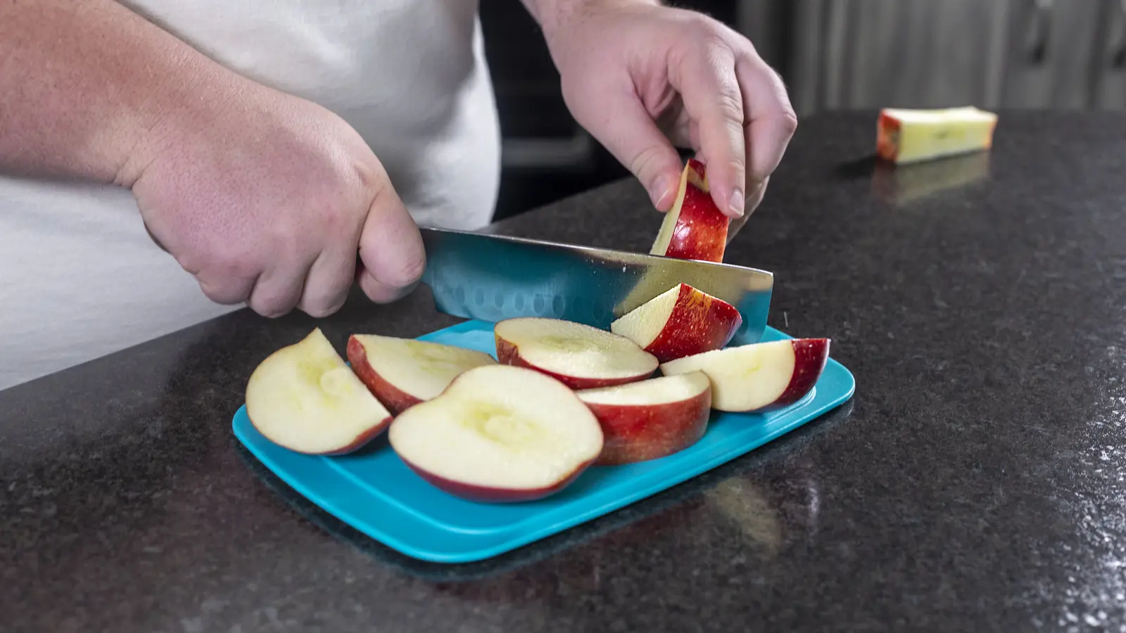 Fresh apple being sliced on a cutting board