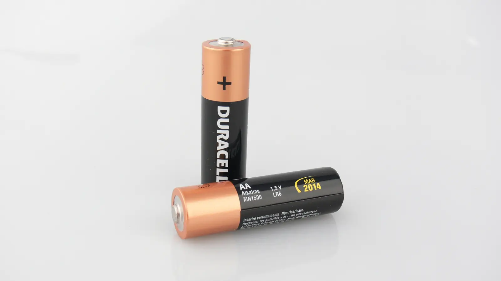 Close-up photograph of a standard AA alkaline battery on a plain background