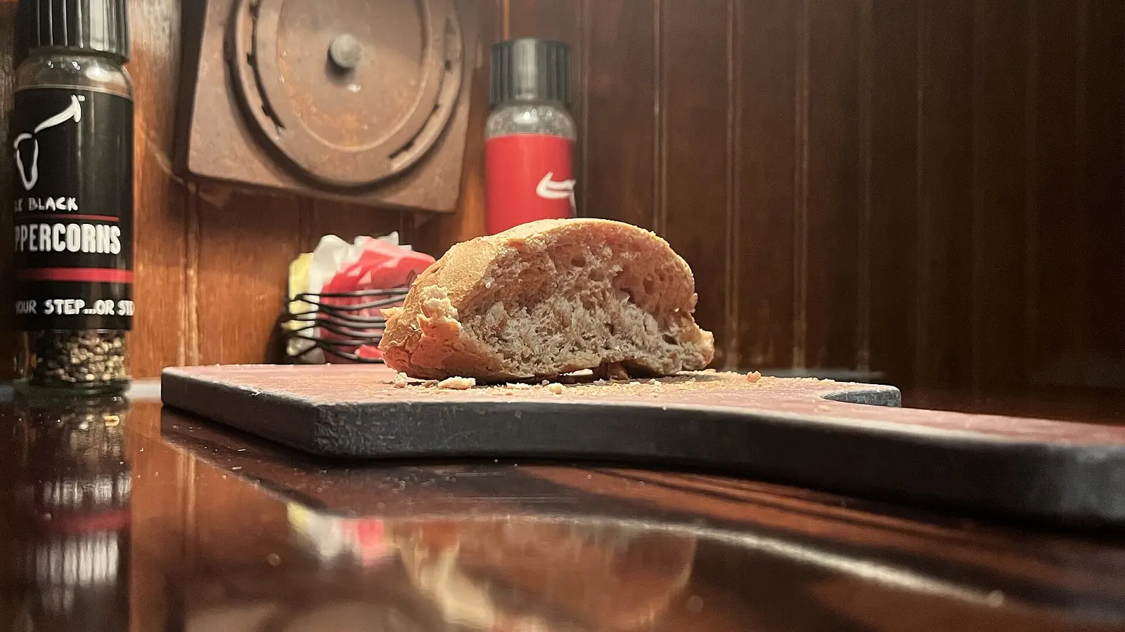 Sliced loaf of bread on a wooden cutting board under warm light