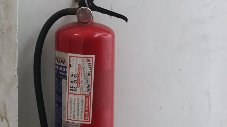 Red portable fire extinguisher mounted on an office wall
