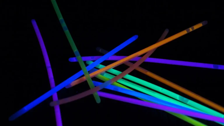 Several coloured glow sticks shining against a dark background