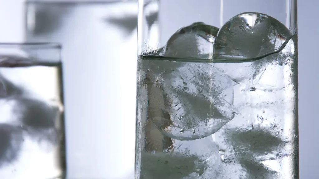 Clear ice cubes floating at the surface of water in a glass
