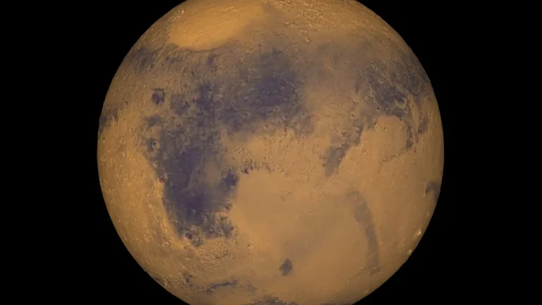 Reddish globe of Mars photographed against a dark background