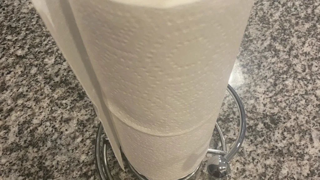 White roll of embossed paper towels standing upright on a countertop