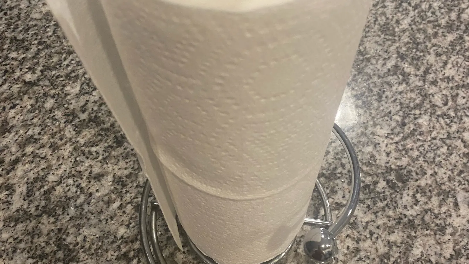 White roll of embossed paper towels standing upright on a countertop
