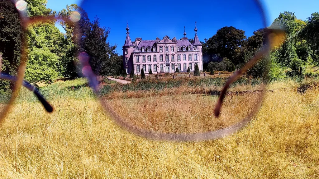 View of a sunlit castle framed through the lenses of a pair of sunglasses