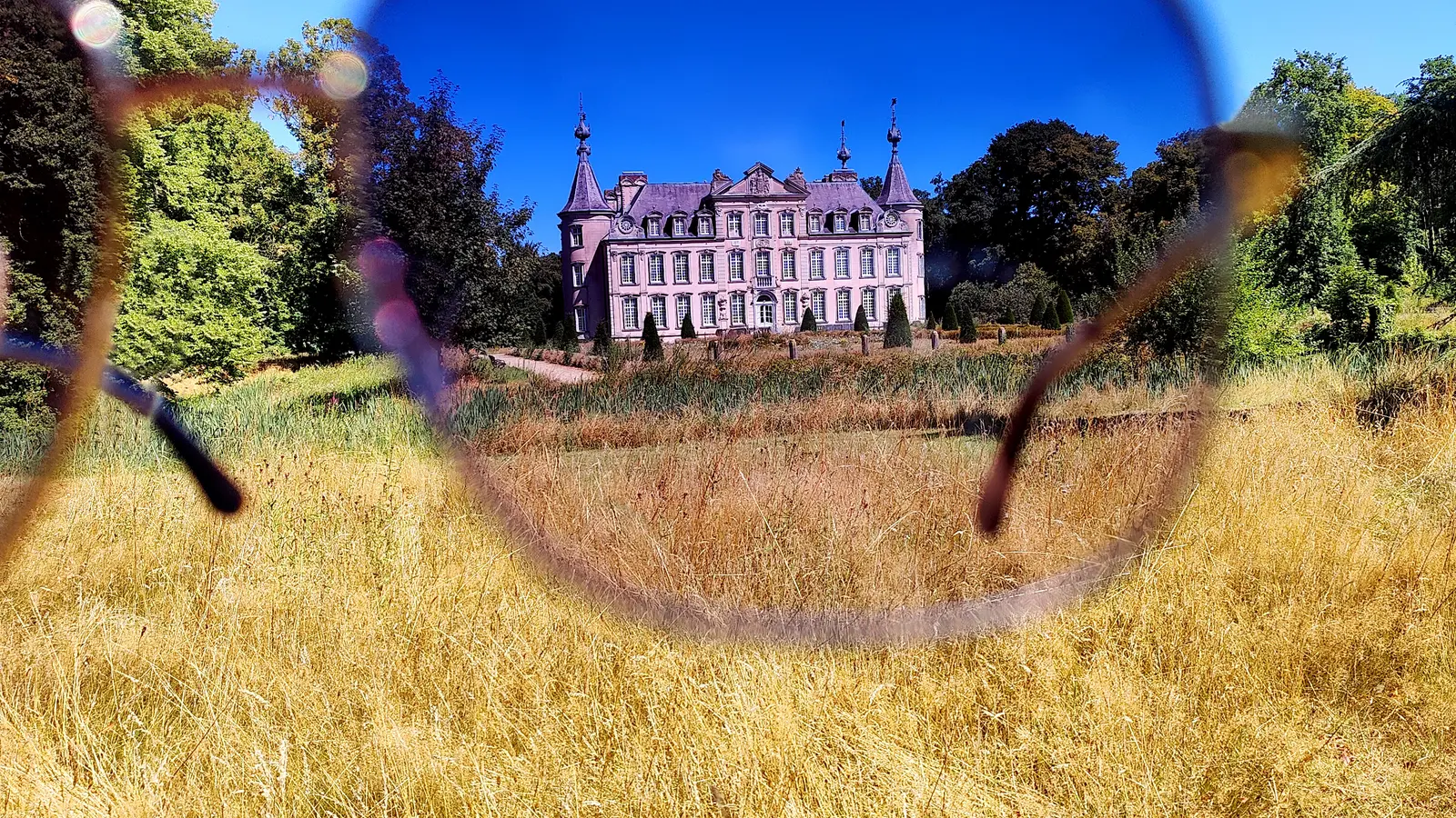 View of a sunlit castle framed through the lenses of a pair of sunglasses