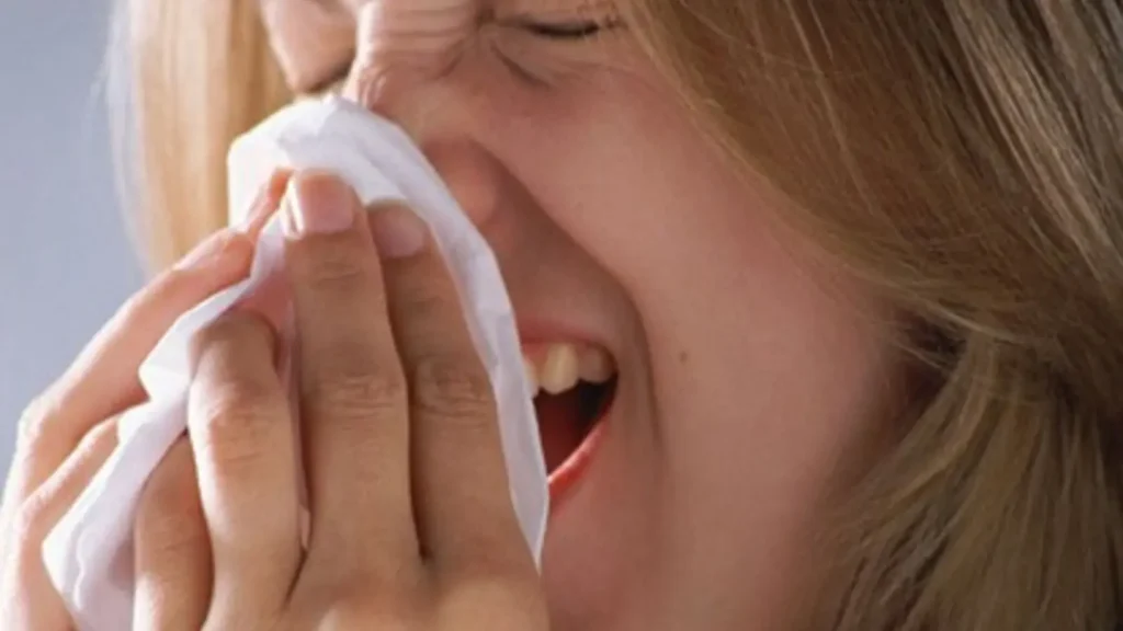Woman using a tissue while sneezing at Minot Air Force Base
