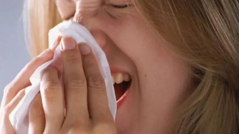 Woman using a tissue while sneezing at Minot Air Force Base