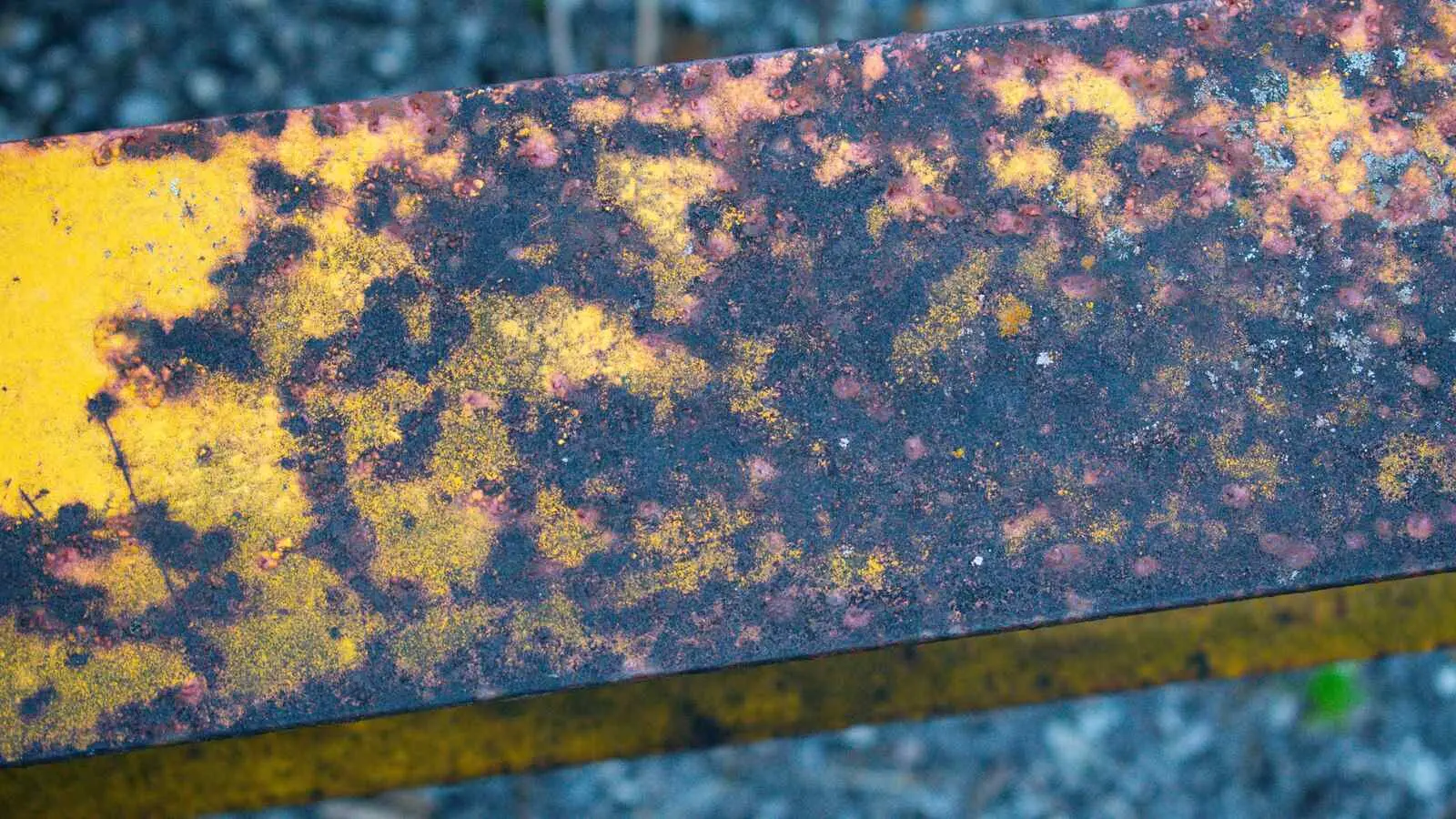 Close-up of orange corrosion covering weathered metal machinery